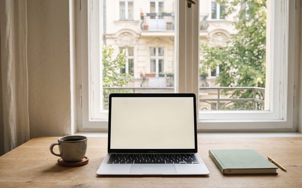 Laptop am Fenster mit Blick auf eine Berliner Altbaufassade