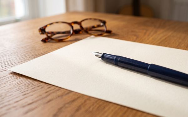 Bogen Papier mit Füllfederhalter auf einem Schreibtisch